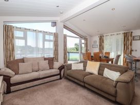 A living room with sofas and a dining area at Skyview in Newton Ferrers