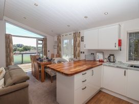 A kitchen with an island and dining table at Skyview Newton Ferrers