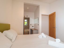 A bedroom with a bed and a door leading to a bathroom at Skyview in Newton Ferrers