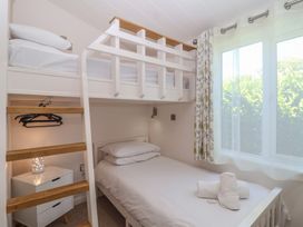 A bedroom with a bunk bed and a single bed at Skyview in Newton Ferrers