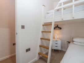 A bedroom with a bunk bed and nightstand at Skyview in Newton Ferrers