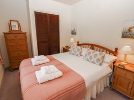 A bedroom with a double bed two nightstands a wooden chest of drawers and folded towels at Periwinkle Akeld near Wooler