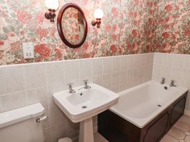 A bathroom with a sink toilet and bathtub with floral wallpaper at Periwinkle in Akeld near Wooler
