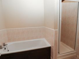 A bathroom with a bathtub and a separate shower cubicle at Lavender cottage in Akeld near Wooler