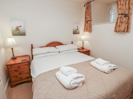 A bedroom with a double bed two bedside tables with lamps and towels on the bed at Freesia Cottage Akeld near Wooler