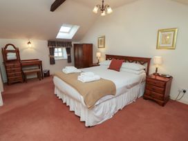 A bedroom with a bed towels on a blanket two bedside tables lamps a wardrobe and a dressing table at Aubretia Trail Akeld near Wooler