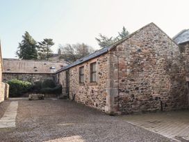 Exterior stone building with gravel ground and shrubbery at Bizzie Lizzie Akeld near Wooler