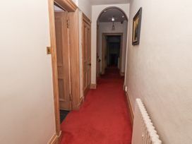A hallway with red carpet wooden doors and an archway at Cheviot Manor in Akeld near Wooler