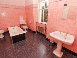 A bathroom with a bathtub bidet toilet sink mirror and window at Cheviot Manor in Akeld near Wooler