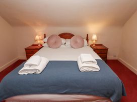 A bedroom with a bed two round pillows bedside tables lamps and folded towels at Cheviot Manor in Akeld near Wooler