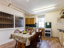 A kitchen with a table and chairs at Cheviot Manor in Akeld near Wooler