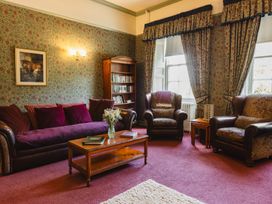 A living room with a coffee table and bookshelf at Cheviot Manor near Wooler