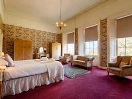 A bedroom with a bed and wardrobe at Cheviot Manor in Akeld near Wooler