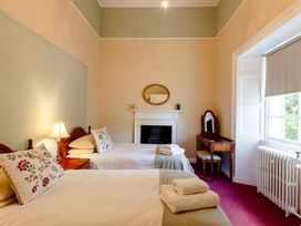 A bedroom with two beds and a fireplace at Cheviot Manor Akeld near Wooler