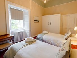A bedroom with two beds and a window at Cheviot Manor in Akeld near Wooler