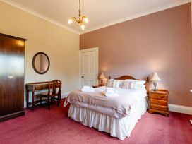 A bedroom with a bed and wardrobe at Cheviot Manor Akeld near Wooler