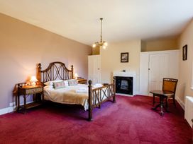 A bedroom with a bed and a chair at Cheviot Manor Akeld near Wooler