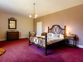 A bedroom with a bed and nightstands at Cheviot Manor in Akeld near Wooler
