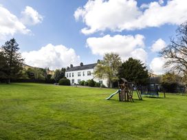 An outdoor area with a house and playground equipment at Cheviot Manor Akeld near Wooler