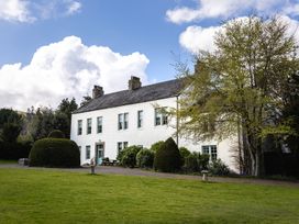 A house with trees and bushes in the garden at Cheviot Manor Akeld near Wooler
