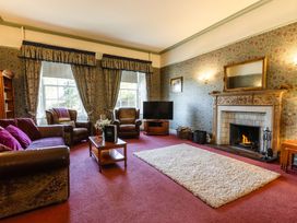 A living room with a fireplace and sofa at Cheviot Manor Akeld near Wooler