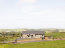 A stone house with a fence and gravel path at Golygfa Cwrt near Bontgoch and Penrhyncoch
