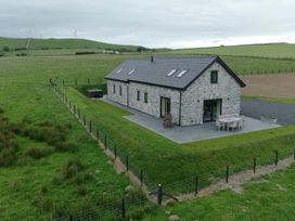 A house with a patio and hot tub near green fields at Golygfa Cwrt near Bontgoch and Penrhyncoch
