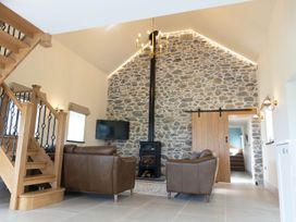 A living room with a stone wall and a television at Golygfa Cwrt near Bontgoch and Penrhyncoch