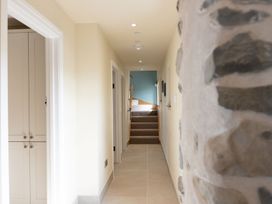 A hallway with a staircase and a closet at Golygfa Cwrt near Bontgoch and Penrhyncoch