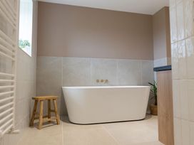 A bathroom featuring a bathtub and stool at Golygfa Cwrt near Bontgoch and Penrhyncoch