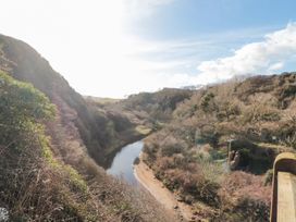 A river flowing through a valley with trees and bushes on both sides at The Blacksmith's Shop in Staithes