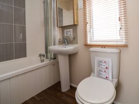 A bathroom with a bathtub shower sink toilet and window blinds at Hazel Park Lodge HP4 in Rhyl