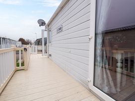 An outdoor deck area with railing and a white door on a mobile home at Hazel Park Lodge HP4 in Rhyl