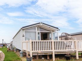 An exterior view of a mobile home with a small porch and railing at Hazel Park Lodge HP4 in Rhyl