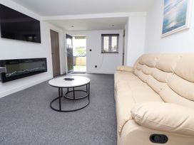 A living room with a sofa and coffee table at 4 Willow Grove - Freehold in Talacre