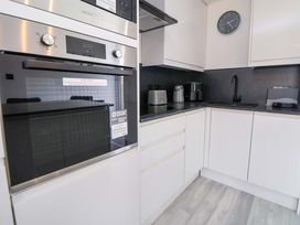A kitchen with built-in oven, microwave, and appliances at 4 Willow Grove - Freehold Talacre