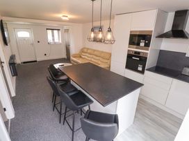 A kitchen with a sofa and kitchen island at 4 Willow Grove - Freehold Talacre