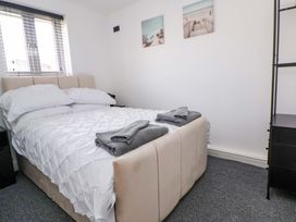 A bedroom with a bed, bedding, towels, and a nightstand at 4 Willow Grove - Freehold Talacre