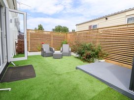 A garden with a sofa set and coffee table at 4 Willow Grove - Freehold Talacre