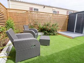 A garden with chairs and a table at 4 Willow Grove - Freehold in Talacre