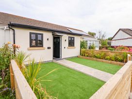 A front view of a house with a pathway and garden at 4 Willow Grove in Talacre