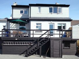 The back of a two story house with a raised deck patio and outdoor furniture at Gweedore Homestead in Bunbeg near Derrybeg County Donegal