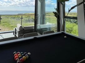 A room with a pool table and a seating area on a balcony with sea views at The Links 40 An apartment with spectacular sea views in Porthcawl