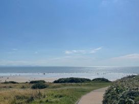 A pathway leading to a beach with people near the water at The Links 40. An apartment with spectacular sea views in Porthcawl
