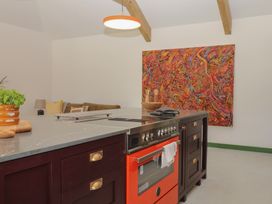 A kitchen with a stove and island at Reddaway Threshing Barn near Okehampton