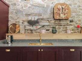 A kitchen with a sink and various decor at Reddaway Threshing Barn near Okehampton