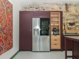 A kitchen with refrigerator and coffee maker at Reddaway Threshing Barn near Okehampton