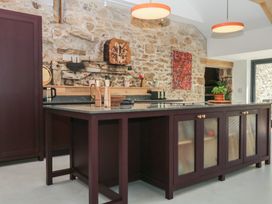 A kitchen with a stone wall and an island at Reddaway Threshing Barn near Okehampton