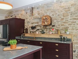 A kitchen with stone wall and modern appliances at Reddaway Threshing Barn near Okehampton