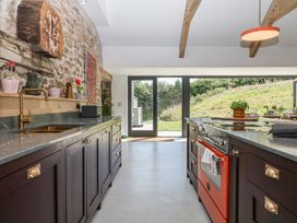 A kitchen with cabinets and appliances at Reddaway Threshing Barn near Okehampton